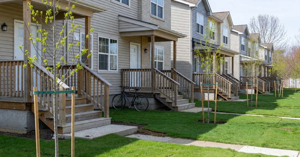 A row of new townhouses with small front porches and young trees, illustrating automating FHSA contributions in Canada.