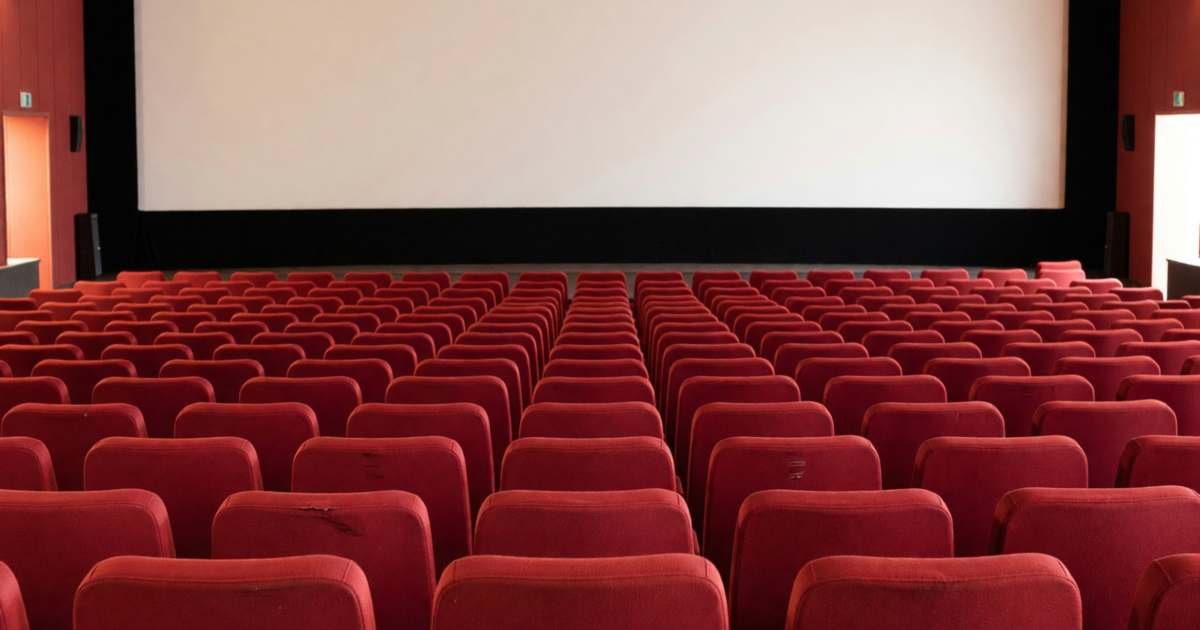 Rows of empty red cinema seats facing a blank screen, illustrating whether Cineplex CineClub is worth it.