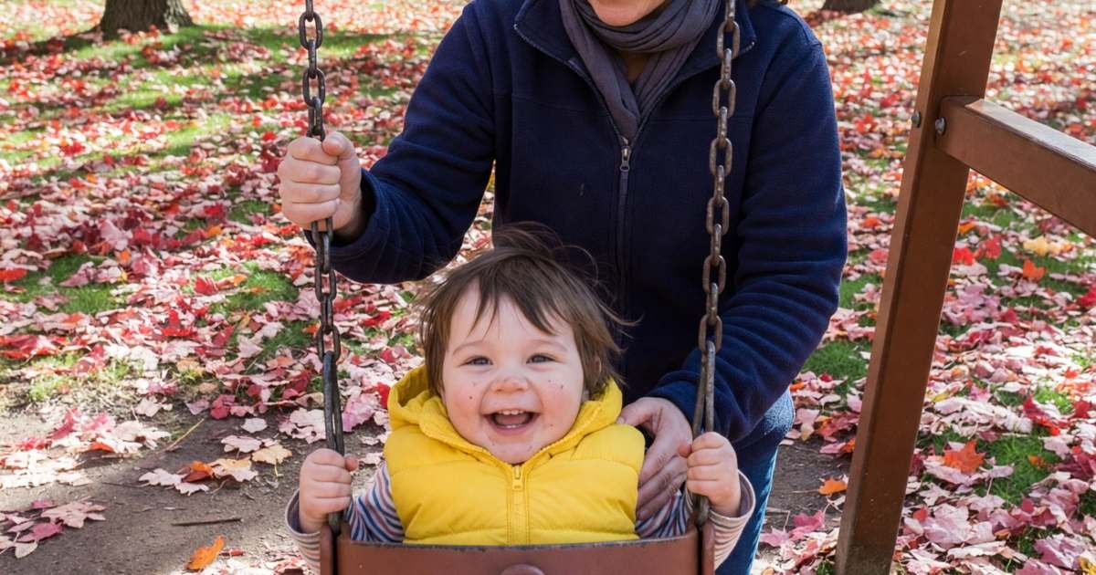 A nanny pushing a toddler on a playground swing, illustrating hiring a nanny in Canada and the real cost.