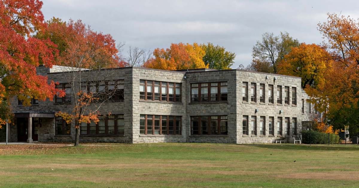 A private school building with a stone façade and an empty playing field, illustrating whether private school tuition is tax deductible.