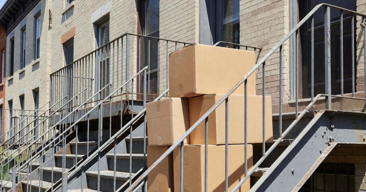 Exterior metal staircases of a row of Montréal walk-up apartments with moving boxes stacked on a landing, illustrating security deposits for Québec renters.