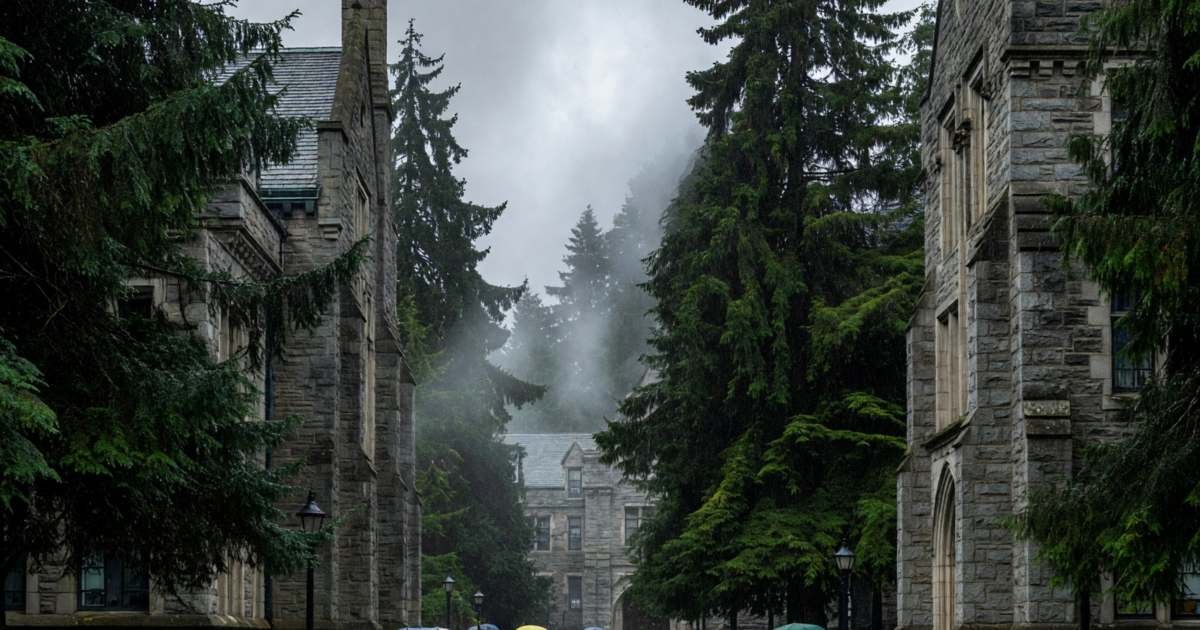 A university campus on a rainy day with students under umbrellas and evergreens, illustrating StudentAid BC 2026-27.