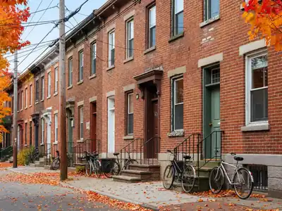 A Toronto row house street with overhead cables strung between wooden utility poles.