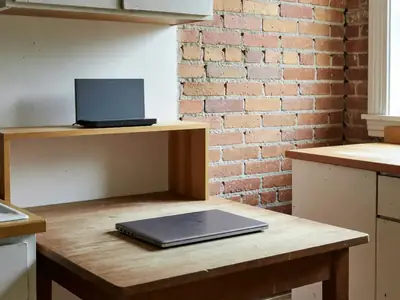 A bright Québec apartment kitchen with a laptop closed on the table and a plain router on a shelf.