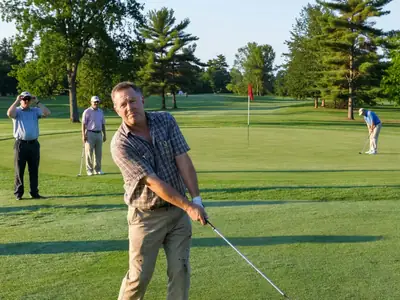 A man teeing off on a public golf course in the morning.