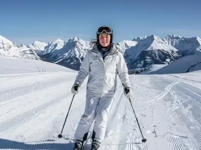 A young woman skiing down a groomed run, out of province on a winter trip.