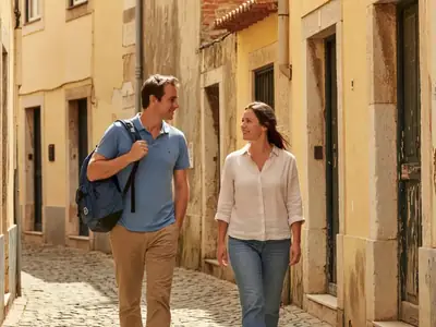 A Canadian couple walking down a sunny cobblestone street abroad with a daypack.