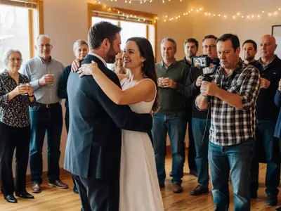 A videographer filming a couple's first dance with a handheld stabilizer.